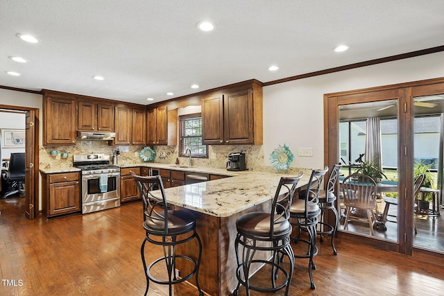 203 Marlowe Dr, Dunn, NC 28334 - kitchen with appliances with stainless steel finishes, under cabinet range hood, a sink, ornamental molding, and a peninsula
