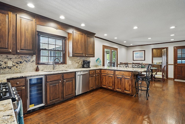 203 Marlowe Dr, Dunn, NC 28334 - kitchen featuring wine cooler, appliances with stainless steel finishes, a sink, a peninsula, and a breakfast bar
