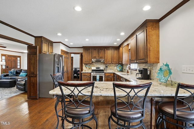 203 Marlowe Dr, Dunn, NC 28334 - kitchen featuring stainless steel appliances, under cabinet range hood, a sink, a peninsula, and ornamental molding