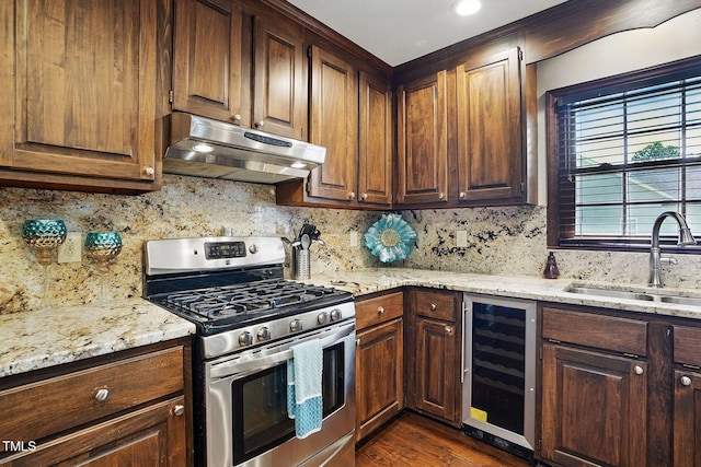 203 Marlowe Dr, Dunn, NC 28334 - kitchen featuring stainless steel range with gas stovetop, wine cooler, under cabinet range hood, a sink, and decorative backsplash