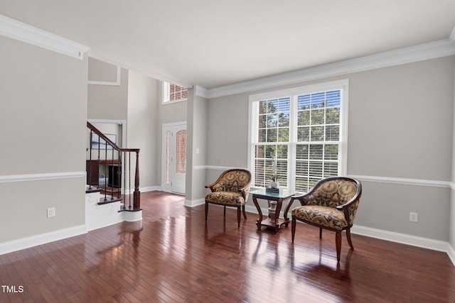 living area featuring healthy amount of natural light, stairs, hardwood / wood-style floors, ornamental molding, and baseboards