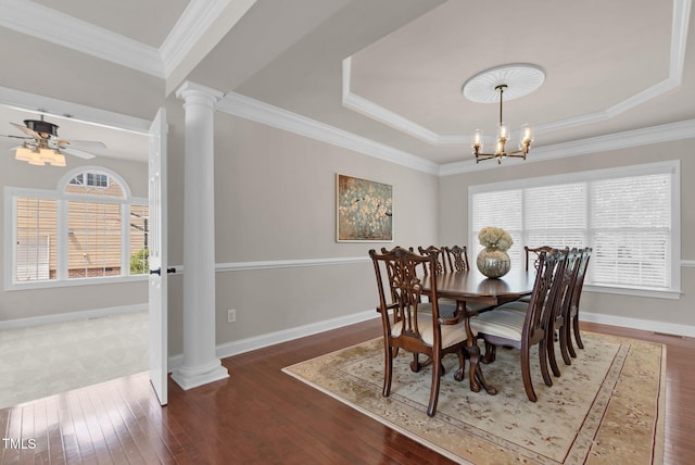 dining room featuring ornate columns, plenty of natural light, hardwood / wood-style floors, baseboards, and crown molding
