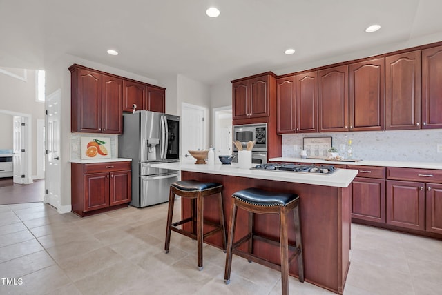 kitchen with stainless steel appliances, light countertops, tasteful backsplash, a breakfast bar area, and recessed lighting