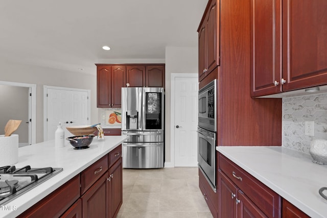 kitchen featuring stainless steel appliances, light countertops, reddish brown cabinets, backsplash, and recessed lighting