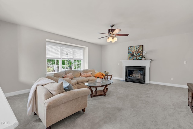 living room with ceiling fan, light carpet, a fireplace with flush hearth, and baseboards