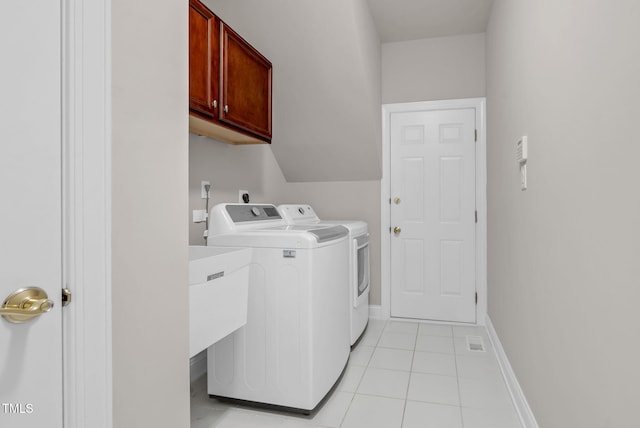 clothes washing area featuring cabinet space, washer and clothes dryer, light tile patterned floors, and baseboards