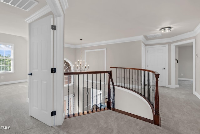 hall featuring carpet, an upstairs landing, a chandelier, crown molding, and baseboards