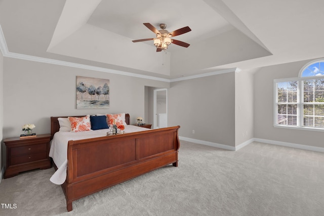 bedroom with a tray ceiling, light carpet, baseboards, and crown molding