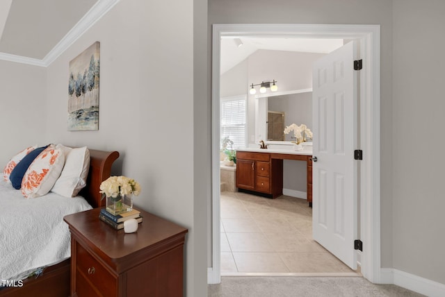 bedroom with ornamental molding, connected bathroom, an office area, baseboards, and light colored carpet