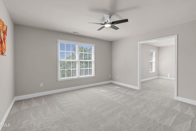 empty room featuring light carpet, plenty of natural light, and ceiling fan