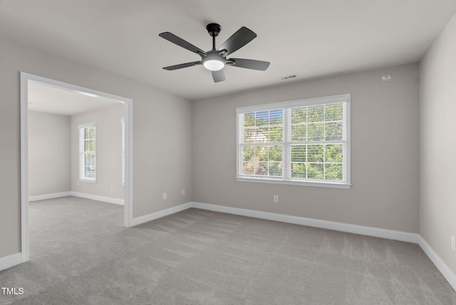 carpeted empty room with plenty of natural light, baseboards, and ceiling fan