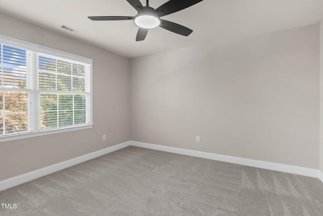 spare room with light carpet, a ceiling fan, and baseboards