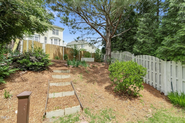 view of yard featuring fence and a garden