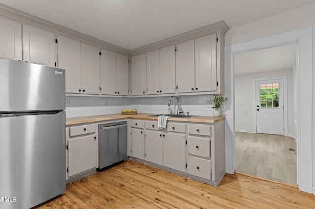 306 Coleman St, Oxford, NC 27565 - kitchen featuring appliances with stainless steel finishes, a sink, light wood-style flooring, and baseboards