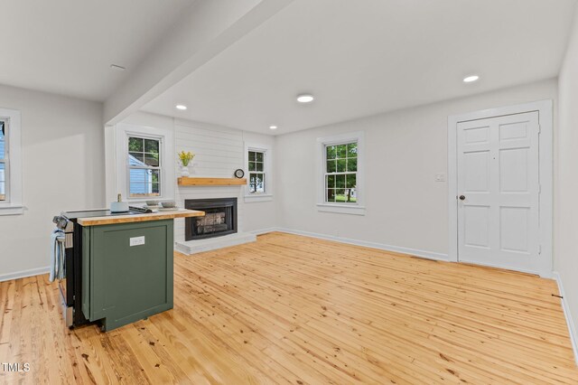 306 Coleman St, Oxford, NC 27565 - kitchen featuring green cabinets, light wood-type flooring, plenty of natural light, a fireplace with raised hearth, and recessed lighting