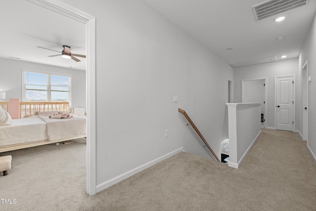 hallway featuring an upstairs landing, carpet flooring, and baseboards