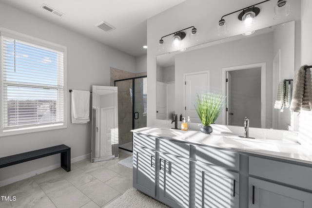 full bath with a shower stall, double vanity, and baseboards