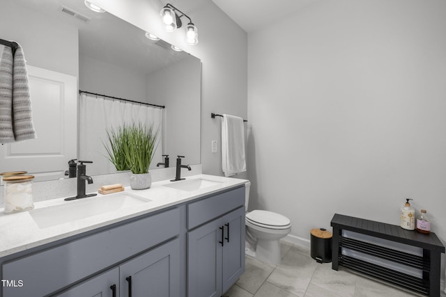 full bath with toilet, double vanity, and curtained shower