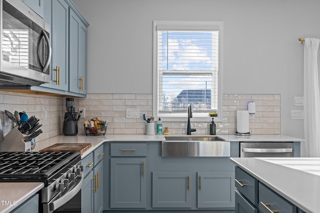 kitchen featuring stainless steel appliances, a sink, decorative backsplash, and plenty of natural light