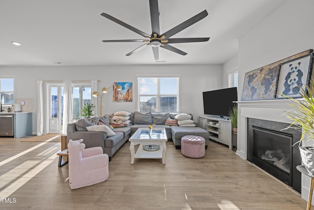 living room with healthy amount of natural light, light wood finished floors, a ceiling fan, and recessed lighting