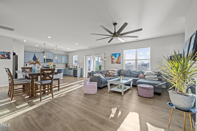 living room featuring wood finished floors, ceiling fan, and recessed lighting