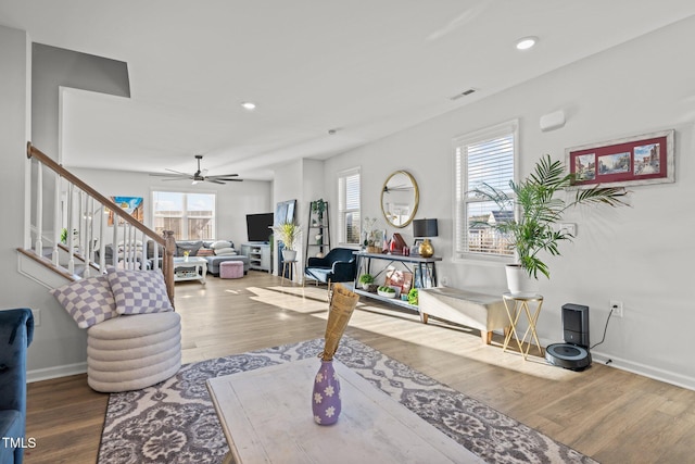 living room with wood finished floors, ceiling fan, recessed lighting, baseboards, and stairs