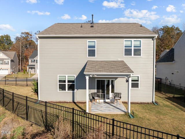 rear view of house with a shingled roof and a patio area