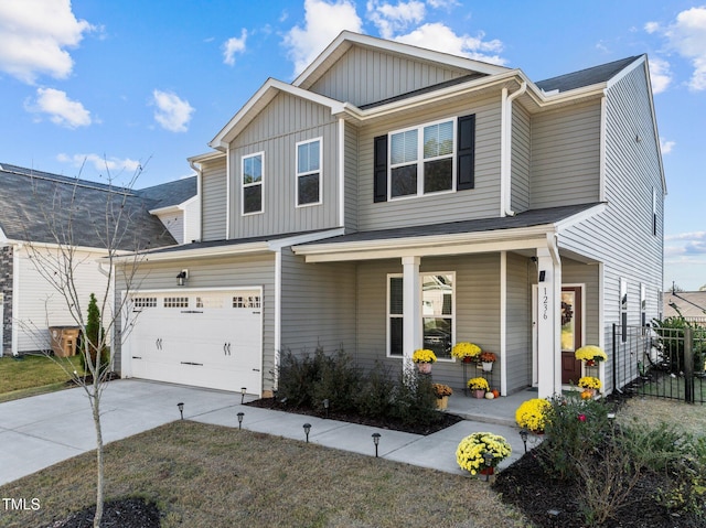 view of front of home featuring board and batten siding, fence, covered porch, and concrete driveway