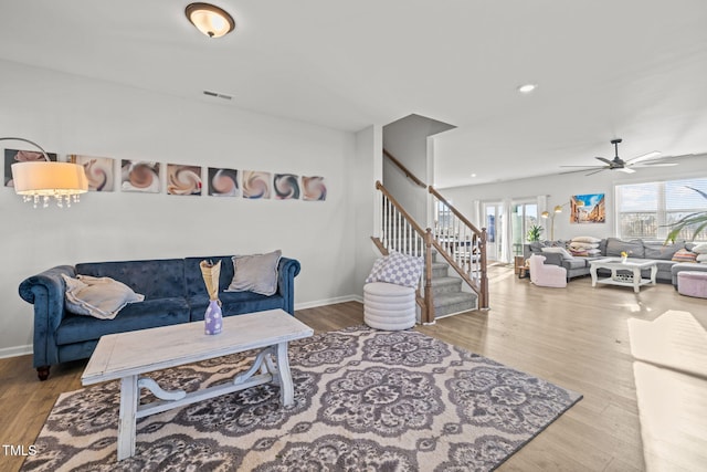 living room featuring stairway, a ceiling fan, wood finished floors, baseboards, and recessed lighting