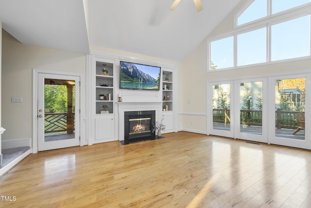 50 Tyler Ct, Henderson, NC 27537 - unfurnished living room with high vaulted ceiling, a fireplace with flush hearth, light wood-type flooring, plenty of natural light, and a ceiling fan