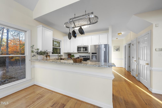 50 Tyler Ct, Henderson, NC 27537 - kitchen with appliances with stainless steel finishes, a peninsula, light wood-style floors, and light stone counters