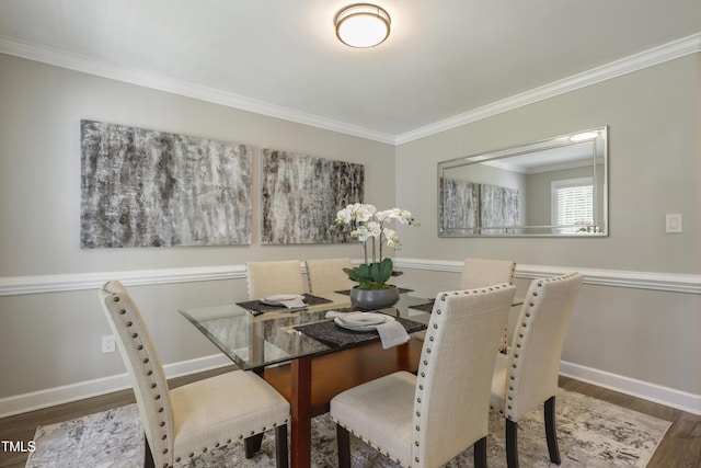 dining area with wood finished floors, crown molding, and baseboards