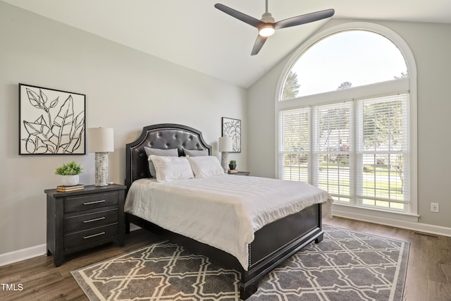 bedroom featuring baseboards, dark wood-type flooring, high vaulted ceiling, and ceiling fan