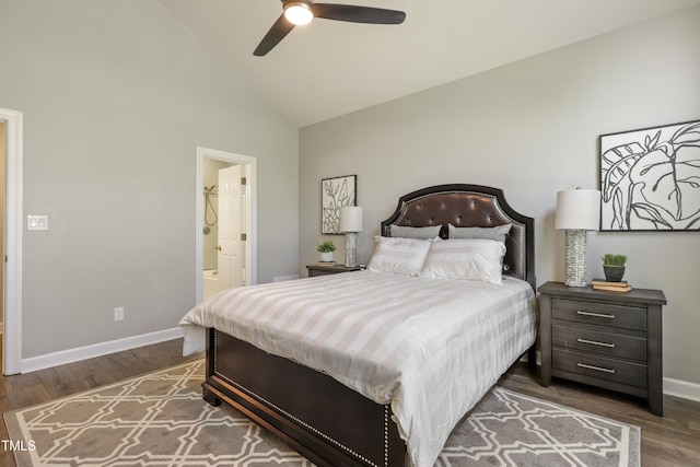 bedroom featuring baseboards, wood finished floors, high vaulted ceiling, and ensuite bath