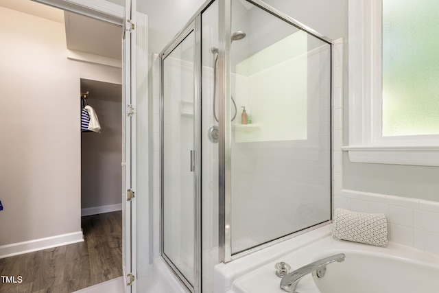 full bath featuring a shower stall, wood finished floors, and a garden tub