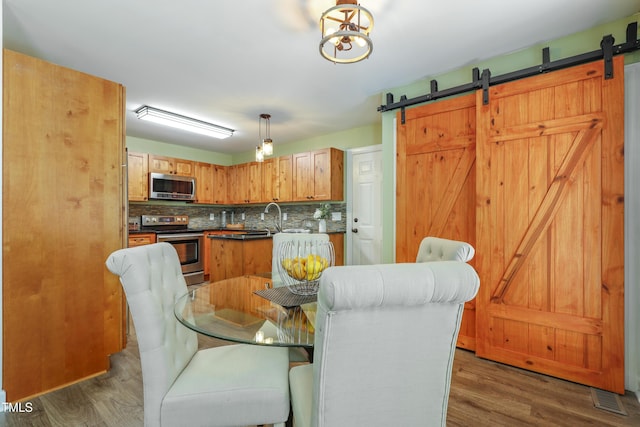 dining space featuring a barn door and dark wood-style floors