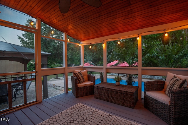 sunroom featuring lofted ceiling, a ceiling fan, and outdoor lounge area