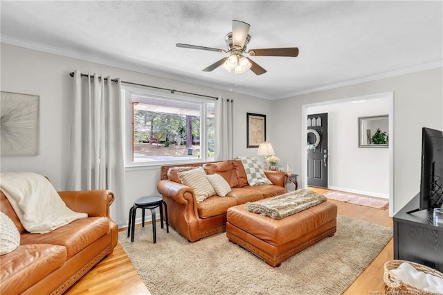 living room with ceiling fan, crown molding, wood finished floors, and baseboards