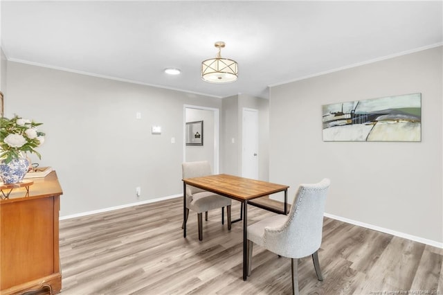 dining space featuring light wood-type flooring, baseboards, crown molding, and recessed lighting