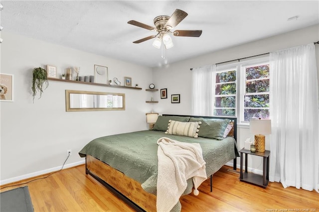 bedroom with wood finished floors, ceiling fan, and baseboards