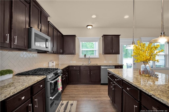 1401 Draw Bridge Ln, Fayetteville, NC 28312 - kitchen featuring appliances with stainless steel finishes, a sink, dark brown cabinetry, light stone counters, and light wood finished floors