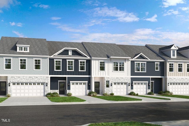 townhome / multi-family property with stone siding, a garage, driveway, and board and batten siding