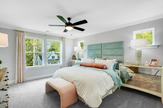 carpeted bedroom with ornamental molding, multiple windows, baseboards, and ceiling fan
