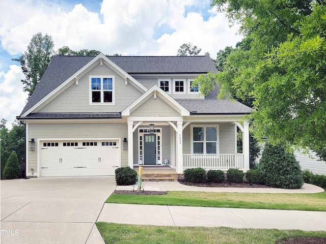 craftsman house with a porch, driveway, roof with shingles, and an attached garage