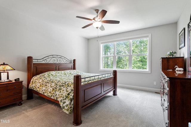 bedroom with light colored carpet, baseboards, and ceiling fan