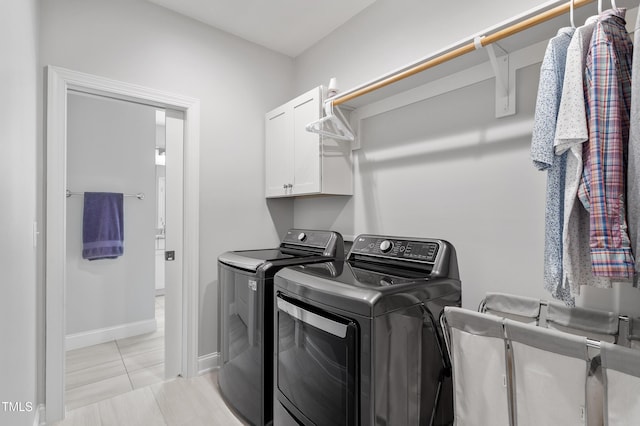 washroom featuring independent washer and dryer, cabinet space, baseboards, and light tile patterned flooring