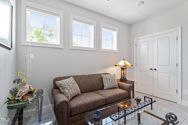 living area with light colored carpet and baseboards