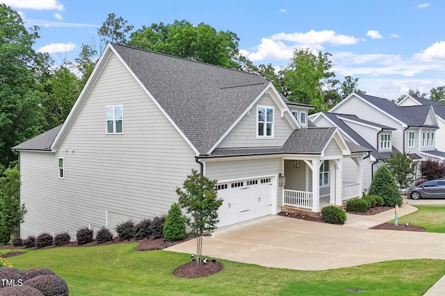 view of front of home with roof with shingles, covered porch, a front lawn, and concrete driveway