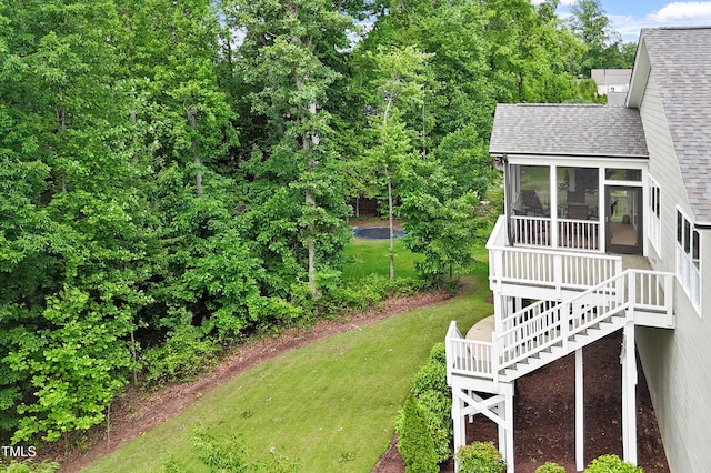 view of grassy yard with a sunroom and stairs