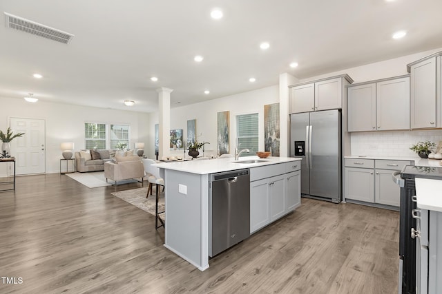 69 Curling Creek Dr Unit I286, Clayton, NC 27527 - kitchen with stainless steel appliances, a kitchen island with sink, light wood-style floors, gray cabinets, and recessed lighting